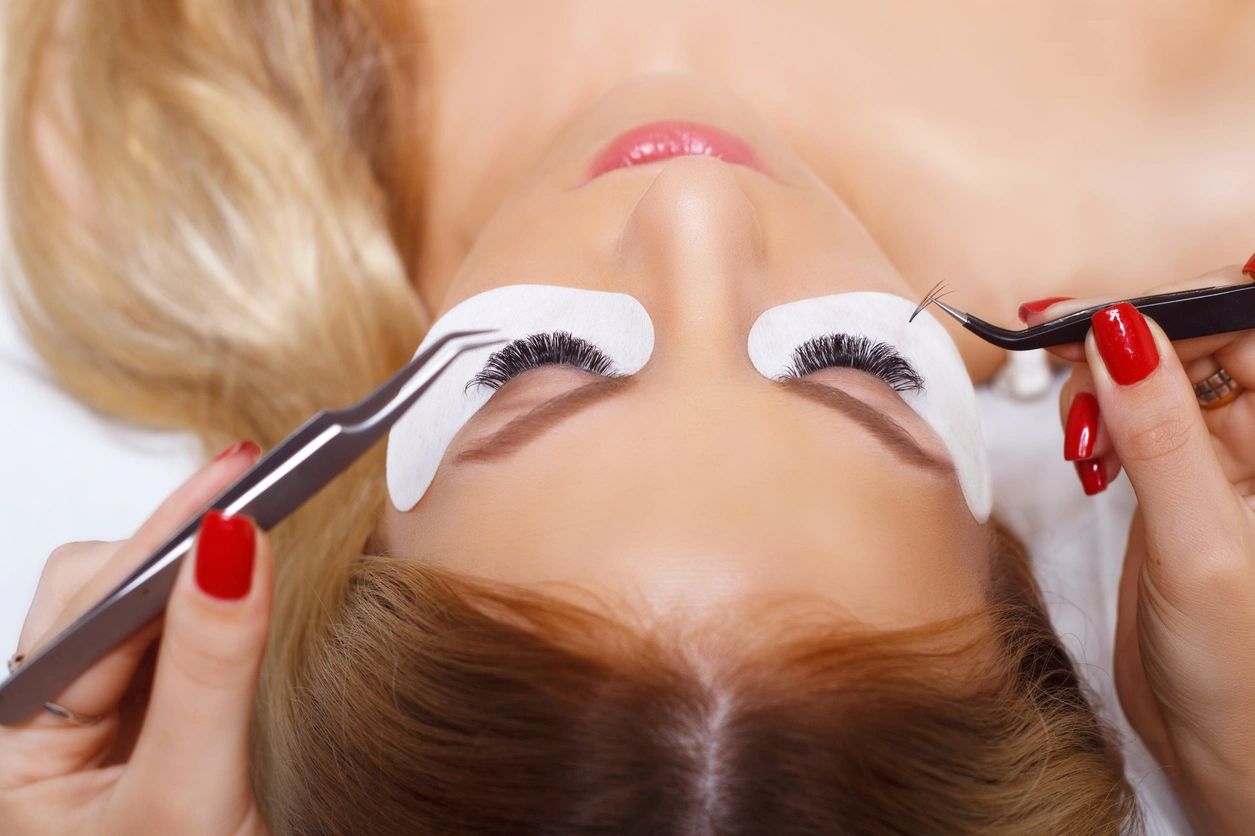 lady getting extensions attached to her lashes at an eyelash salon near me